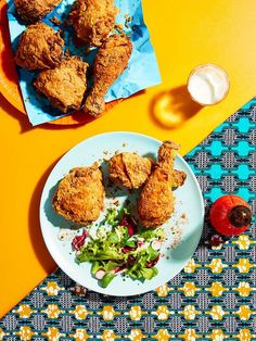 fried chicken on a plate next to a salad