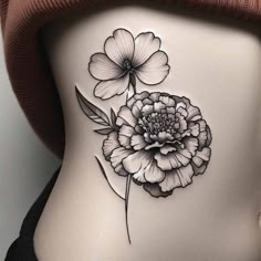 a black and white flower tattoo on the back of a woman's stomach,