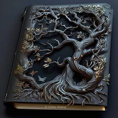 an intricately carved book with a tree on it's cover is shown in this image