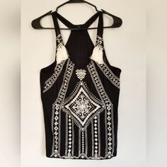 Women's Banana Republic Sleeveless Top Halter Style Black With Cream Colored Embroidery Tassel Both Sides Size Small Round Neckline Nwot. Measurements; Pit To Pit 16 Inches Length 27 Black Sleeveless Tank Top For Festival, Black Sleeveless Top For Festival, Bohemian Sleeveless Tank Top For Party, Chic Embroidered Sleeveless Tops, Black Sleeveless Halter Top For Festival, Sleeveless Embroidered Vest For Summer, Sleeveless Embroidered Festival Top, Embroidered Sleeveless Festival Top, Black Sleeveless Festival Vest