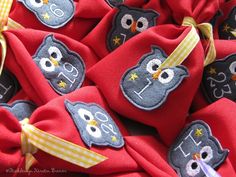 red cloth bags with embroidered owls and numbers on the front, tied together in yellow ribbon