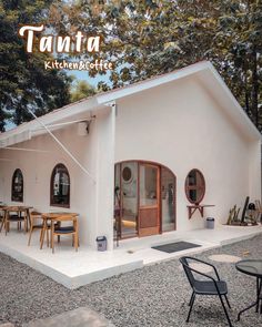 a small white house sitting on top of a gravel field