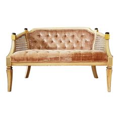 an old fashioned couch with cane legs and gold upholstered fabric on the back