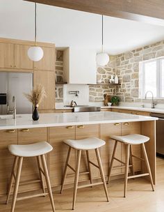 a kitchen with two stools and an island