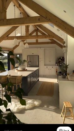 an open kitchen and dining area with wooden beams