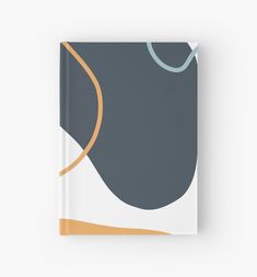 a book with an abstract design in grey and orange on the cover, sitting on a white surface