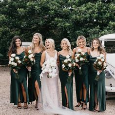 a group of women standing next to each other in front of a white car and trees