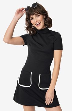 With its 1960s vibes, mock turtleneck, and sleek short sleeves, the Wave Maker shift dress is a must-have. The darted bodice and tapered waist create a flattering silhouette, while the A-line skirt dances above your knees. Complete with side pockets and a back button keyhole for added convenience. Unlined Back Button Keyhole Side Pockets Material Hs Stretch Mock Neck Short Sleeve, Vintage Black Dress, Tulip Sleeve, Shift Dress Black, Mod Dress, Green Midi Dress, Mock Turtleneck, The Wave, Long Sleeve Shirt Dress