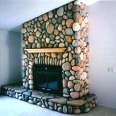 a living room with a stone fireplace and white walls