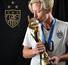 a man kissing the golden ball trophy in front of a black wall with stars on it