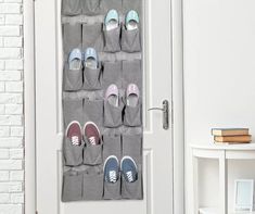 several pairs of shoes are hanging on the door