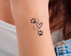 a woman with a tattoo on her arm and paw prints in the shape of a heart