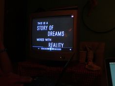 a person sitting in front of a tv with a message on it that reads, this is a story of dreams mixed with reality