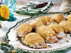 several crab cakes on a plate with flowers and napkins in the backgroud