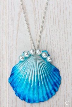 a blue shell with pearls hanging from it