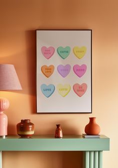 a table with some vases on it and a framed heart poster above the table