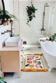 a bath room with a tub a sink and a rug