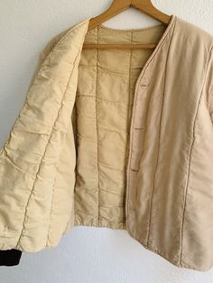 Soft cotton quilted liner jacket in faded peach with brown cuffs. Front buttons. Fabric: Cotton Fit: S Measurements (flat): Armpit to armpit 21 Sleeve 24 Shoulder (across) 17.5 Length (front) 18.25 Length (back) 23 Condition: Excellent Quilted Beige Cotton Outerwear, Beige Quilted Cotton Outerwear, Cotton Button-up Outerwear For Daywear, Cream Cotton Outerwear For Daywear, Cream Cotton Outerwear With Button Cuffs, Vintage Beige Cotton Outerwear, Vintage Cotton Quilted Jacket For Fall, Beige Cotton Outerwear With Snap Buttons, Beige Cotton Outerwear With Buttons