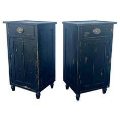 pair of black painted wooden nightstands with brass pulls and knobs on the doors