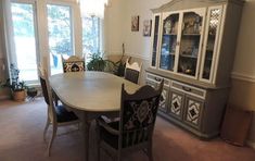 a dining room table with chairs and china cabinet