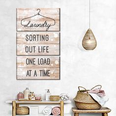 a bathroom with a wooden sign that says laundry sorting out life one load at a time