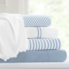 a stack of blue and white sheets on a window sill