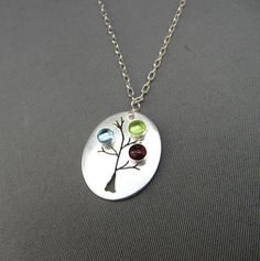 "A unique handmade sterling silver oval pendant featuring an organic tree with your loved ones birthstones. The pendant hangs on a sterling silver chain, your choice of length. The sterling silver oval measures 15/16\" x 3/4\". Each pendant is slightly different due to their handmade nature. Please see below for birthstones available. This listing is for 3 birthstones. **If you need an emerald, there is an additional charge. Please purchase this additional listing: http://www.etsy.com/listing/75 Sterling Silver Birthstone Necklace With Charms For Mother's Day, Silver Birthstone Necklace For Mother's Day Keepsake, Handmade Birthstone Necklace For Anniversary, Mother's Day, Silver Birthstone Necklace For May - Gift For Mom, Multi-stone Birthstone Pendant Necklace Gift, Light Blue Gemstone, Mother Family, Mothers Necklace, Green Quartz