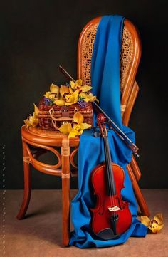 a violin sitting on top of a table next to a chair