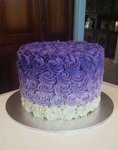 a purple and white cake sitting on top of a table