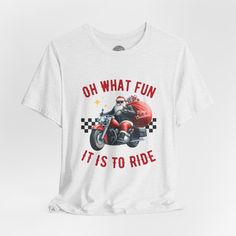 Rev up the festive spirit with our Christmas Sweatshirt! Featuring the spirited phrase "Oh what fun it is to ride," this shirt showcases a Biker Santa Claus on a cruiser delivering presents against a backdrop of racing checkers. Product details This classic unisex jersey short sleeve tee fits like a well-loved favorite. Soft cotton and quality print make users fall in love with it over and over again. These t-shirts have-ribbed knit collars to bolster shaping. The shoulders are tapered for a better fit over time. Dual side seams hold the garment's shape for longer. >Bella Canvas 3001 TShirt >This t-shirt comes with a lightweight fabric (4.2 oz/yd² (142 g/m²)) that is easy to layer thanks to its breathability and the perfect choice for both active and leisure wear. The 100% Airlume combed a Light Font, Oh What Fun, Crew Neck Tshirt, Santa Christmas, Christmas Sweatshirts, Leisure Wear, White Tshirt, Jersey Shorts, Lightweight Fabric