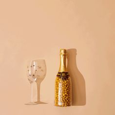 a wine glass and bottle sitting next to each other on a shelf with a wall in the background