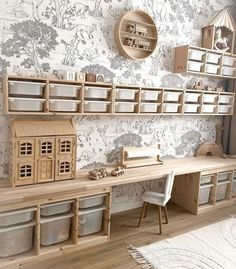 a wooden desk with shelves and bins on the wall, next to a doll house