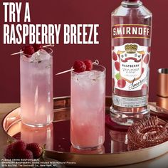 two glasses filled with raspberry breeze on top of a tray