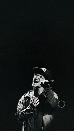 a black and white photo of a man singing into a microphone