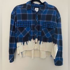 a blue and white plaid shirt hanging on a wall next to a black hanger