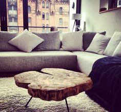 a living room with a couch, coffee table and large window looking out onto the city