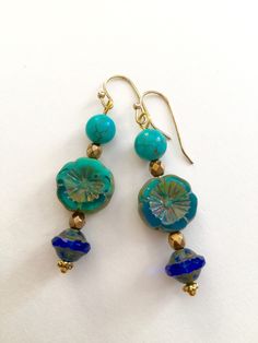 "Lightweight earrings handmade of semi-transparent aqua blue Czech glass Picasso flower, 8mm turquoise howlite, and cobalt blue Picasso UFO bead. Accented with light bronze Czech glass beads and gold wire. Earrings come on simple gold plated fish hook ear wires, lead and nickel free. Measure 2 1/8\"'long from top of ear wire." Turquoise Czech Glass Round Jewelry, Bohemian Blue Nickel-free Flower Earrings, Adjustable Flower Shaped Blue Beaded Earrings, Blue Round Flower Earrings Hypoallergenic, Blue Flower Earrings For Jewelry Making, Adjustable Blue Flower Beaded Earrings, Blue Round Hypoallergenic Flower Earrings, Elegant Blue Czech Glass Flower Earrings, Hypoallergenic Blue Flower Earrings