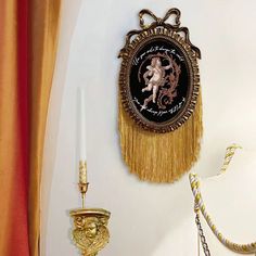 a wall clock that is hanging on the side of a wall next to a candle