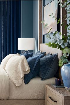 a bedroom with blue walls and white bedding