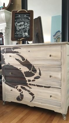 an old dresser with a crab painted on it