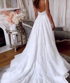 a woman in a white wedding dress standing next to a fireplace