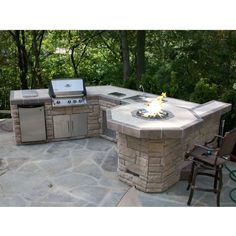 an outdoor kitchen with grill and seating area