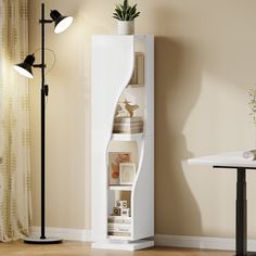 a tall white shelf next to a table with a potted plant on it