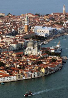 an aerial view of venice, italy with the city in the foreground and boats on the water