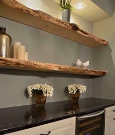 a kitchen with two open shelvings and flowers on the counter top in front of it