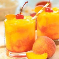 two glasses filled with orange juice and garnished with cherries