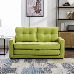 a green couch sitting on top of a rug in a living room