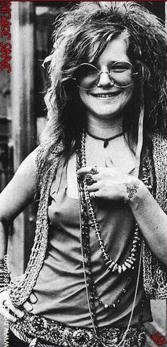 an old photo of a woman with long hair wearing glasses and holding a chain around her neck