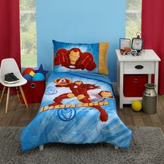 a bedroom with a blue wall and a bed covered in an iron man comforter