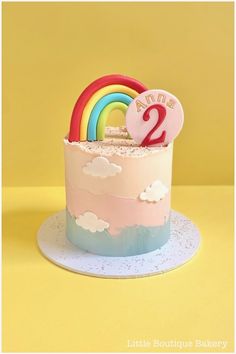 a birthday cake with a rainbow and number two on it